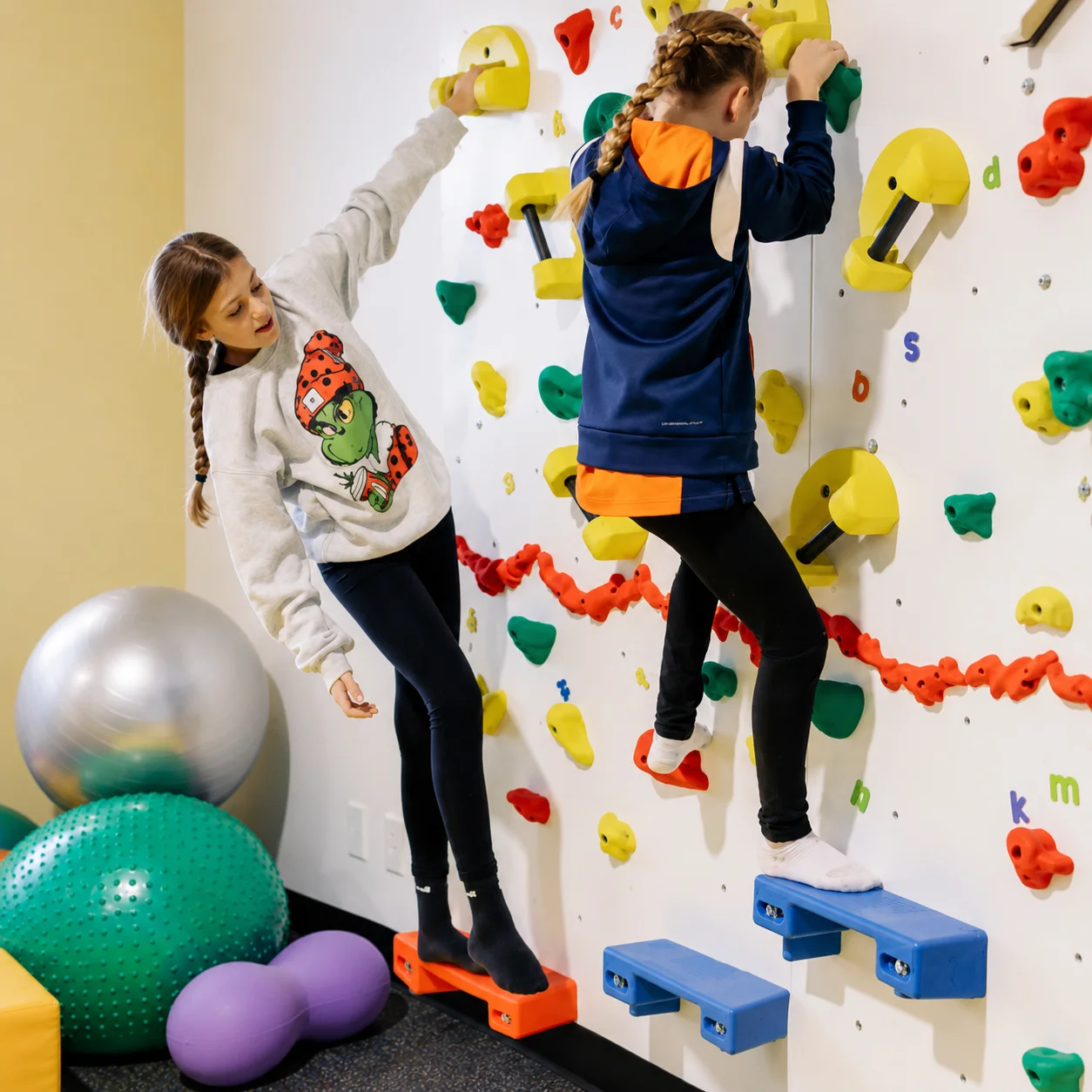 Energetic Explorers class — children on climbing wall and obstacle course